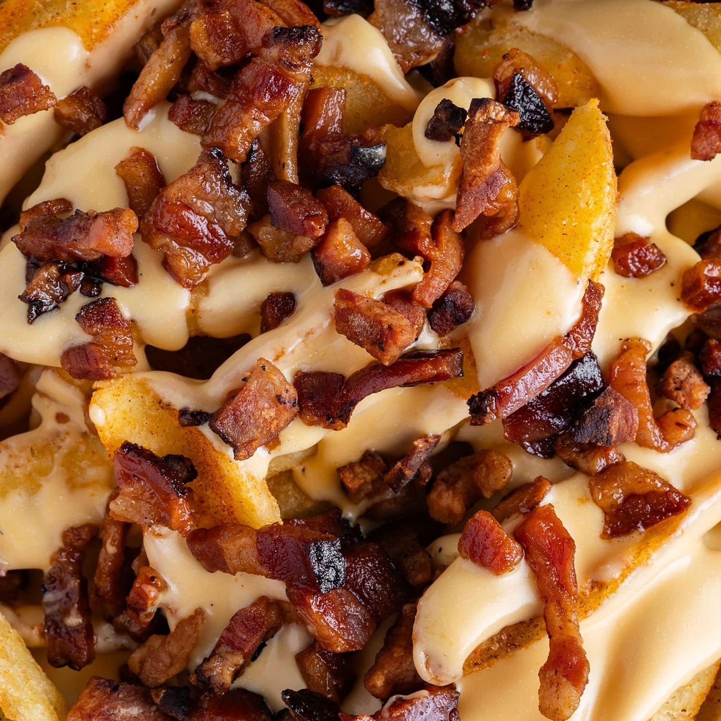 Patatas gringas con cheddar fundido y bacon ahumado, en primer plano